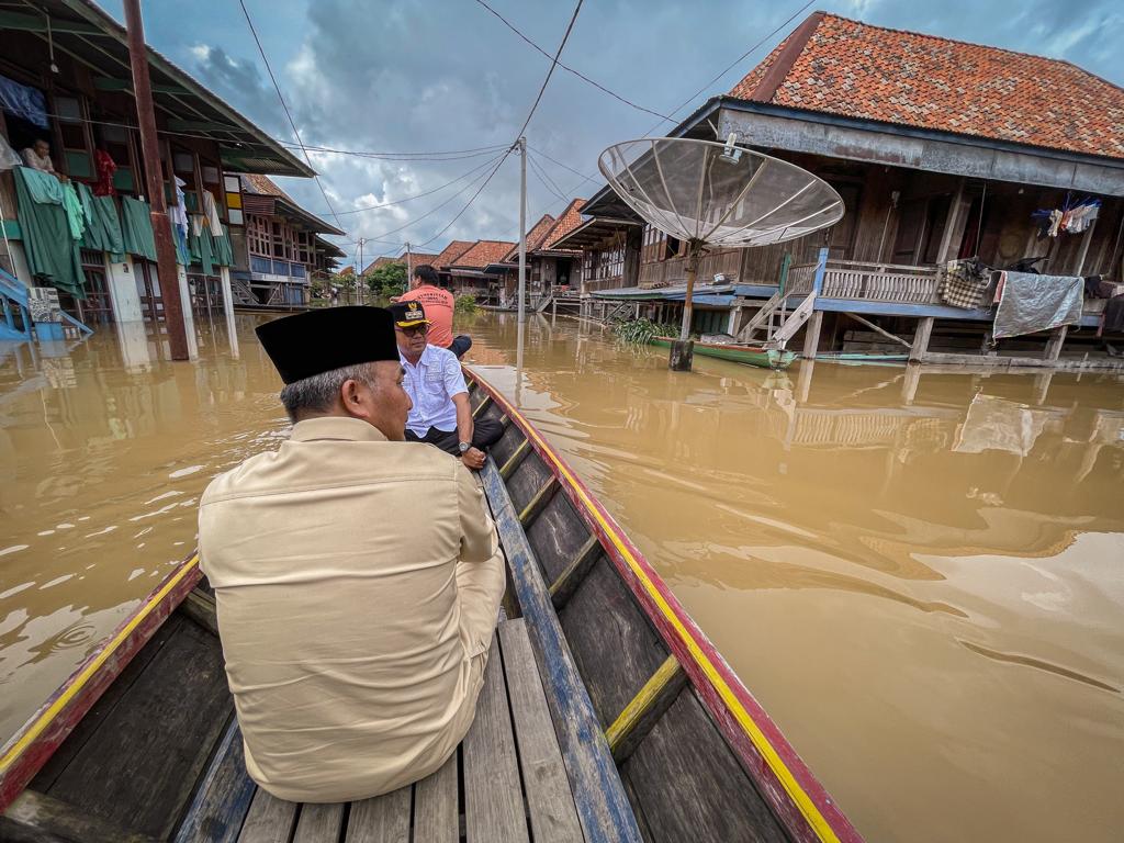 Naik Perahu, Pj H Muba Tinjau dan Beri Bantuan Korban Banjir di Ulak Embacang